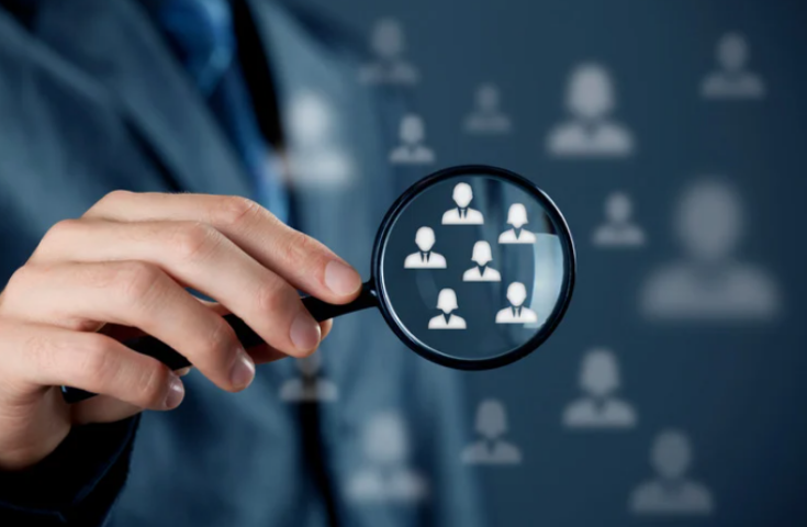 Magnifying glass identifying qualified leads from a wider audience