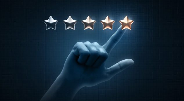 Hand selecting the fifth gold star in a 5-star rating